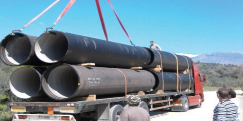 Common ductile iron pipe failures including external corrosion pitting and joint damage Common DI pipe failures: External corrosion, joint damage, and transportation defects ⚡ Quick Answer: The most common problems in ductile iron pipe projects are external corrosion in aggressive soils (caused by inadequate coating specification), joint failure due to poor field joint protection, water hammer damage from ignoring surge pressure, and transportation damage from inadequate packing. These issues can be prevented through proper soil testing, correct coating specification, surge pressure analysis, and third-party pre-shipment inspection. For a complete overview of South Africa water pipeline projects including material selection, standards, procurement, and logistics, see our South Africa Water Pipeline Complete Guide 2026 → Why Do Ductile Iron Pipe Projects Fail? Ductile iron pipe is one of the most reliable materials for water infrastructure, with a proven service life of 50-100+ years. However, failures do occur — and they are almost always preventable. The root causes typically fall into four categories: inadequate corrosion protection, poor joint installation, surge pressure underestimation, and transportation damage. For EPC contractors, municipal engineers, and procurement teams, understanding these failure modes before project execution is critical. Preventing failures during the specification and procurement phase costs a fraction of what repairs cost after pipeline commissioning. Problem 1: External Corrosion in Aggressive Soils External corrosion is the leading cause of premature ductile iron pipe failure. When soil conditions are more corrosive than anticipated, standard zinc + bitumen coating can be consumed within 10-20 years, exposing the iron surface to electrochemical corrosion and causing external pitting. What Causes External Corrosion? Soil corrosivity is determined by several factors: Soil resistivity: Low resistivity (<3,000 Ω·cm) indicates high corrosivity. High resistivity (>10,000 Ω·cm) indicates low corrosivity. pH level: Acidic soils (pH <6.5) and alkaline soils (pH >8.5) accelerate zinc consumption. Chloride content: High chloride concentrations (common in coastal soils near Durban and Cape Town) increase corrosion rates. Sulfate content: Sulfates in soil react with zinc and iron, accelerating coating degradation. Stray current: Electrical currents from nearby railways, tram lines, or cathodic protection systems can cause rapid localized corrosion. How to Prevent External Corrosion Prevention starts with soil testing along the pipeline route. Collect soil samples at 500m intervals (or 100m in areas with known geological variability) and test for resistivity, pH, chloride, and sulfate content. Based on soil test results, specify the appropriate external protection system: Soil Condition Resistivity Recommended Protection Low corrosivity >10,000 Ω·cm Zinc coating (≥130g/m²) + bitumen paint (standard per ISO 8179) Moderate corrosivity 3,000-10,000 Ω·cm Epoxy coating (≥250μm) + bitumen overlay High corrosivity <3,000 Ω·cm Epoxy coating (≥250μm) + polyethylene encasement per ISO 12234 💡 Key Insight: Polyethylene encasement per ISO 12234 is the most cost-effective external protection for aggressive soils. It creates a physical barrier between the pipe surface and corrosive soil elements, extending service life beyond 100 years. PE encasement adds only 3-5% to total pipe cost but can prevent 100% of external corrosion failures. Problem 2: Joint Failure Due to Poor Field Protection Up to 80% of corrosion-related pipe failures occur at joints — the points where two pipe sections connect. This is because field joints are the most vulnerable points in the corrosion protection system. Why Are Joints Vulnerable? Factory-applied coatings (zinc + bitumen or epoxy) cover the pipe body completely. However, at each joint, the coating is interrupted to allow connection. If the joint area is not properly protected during field installation, it becomes an entry point for corrosive soil elements. Common field joint protection failures include: Inadequate surface preparation: Failing to clean and dry the joint surface before applying field coating. Insufficient coating thickness: Applying field coating thinner than manufacturer specifications. Missing PE tape wrapping: Skipping polyethylene tape wrapping at the joint, leaving zinc exposed to soil. Poor inspection: Failing to inspect field joint coating before backfilling, allowing defects to go undetected. How to Prevent Joint Failure Require field joint coating specification in the project documents and verify compliance during installation: Surface preparation: Clean joint surface to SA 2.5 (near-white metal blast cleaning) before applying field coating. Field coating application: Apply two-component epoxy coating (minimum 250μm) to both pipe spigot and bell ends. PE tape wrapping: Wrap joint with polyethylene tape (minimum 0.8mm thickness) extending 150mm beyond the coated area on each side. Inspection: Inspect all field joints before backfilling. Use holiday detection (spark testing) to identify coating defects. Field joint coating application process for ductile iron pipe installation Field joint protection: Epoxy coating and PE tape wrapping at pipe connection points Problem 3: Water Hammer and Surge Pressure Damage Water hammer (surge pressure) occurs when water flow changes direction or velocity suddenly — typically during pump start/stop, valve closure, or emergency shutdown. Surge pressures can reach 2-3x the steady-state operating pressure, causing pipe bursts, joint separations, and fitting failures. How Surge Pressure Damages DI Pipe When surge pressure exceeds the pipe's Pressure Maximum Admissible (PMA), the following failures can occur: Pipe body rupture: Excessive internal pressure causes circumferential cracking, particularly in pipes with manufacturing defects or external corrosion. Joint separation: Surge pressure pushes the spigot end out of the bell joint, breaking the gasket seal and causing high-pressure water leakage. Fitting failure: Bend pieces, tee pieces, and reduction pieces experience concentrated stress at direction changes, causing cracking at the fitting body. How to Prevent Surge Pressure Damage Require a hydraulic surge analysis from the design engineer before finalizing pipe specification. The analysis should identify maximum surge pressure (PMA required) at each pipeline section. Based on surge analysis results: If surge pressure ≤50 bar: K9 class (PMA 50 bar) is sufficient. If surge pressure 50-62.5 bar: Specify K10 class (PMA 62.5 bar). If surge pressure >62.5 bar: Specify K12 class (PMA 78.7 bar) or install surge protection devices (surge tanks, air valves, variable speed drives on pumps). ⚠️ Critical: Never specify pipe based on steady-state operating pressure alone. Always verify PMA rating against maximum surge pressure from hydraulic analysis. A pipeline with 25 bar operating pressure but 55 bar surge pressure requires K10 class (PMA 62.5 bar), not K9 (PMA 50 bar). Problem 4: Transportation and Handling Damage Ductile iron pipe is heavy and robust, but it can still be damaged during transportation and handling. Common transportation damage includes: Coating damage: Pipe-to-pipe contact during ocean transit causes zinc coating abrasion, exposing iron to corrosion. Joint damage: Impact forces during loading/unloading damage spigot and bell ends, preventing proper joint assembly. Gasket damage: Poor packing allows pipe movement, crushing or deforming rubber gaskets stored inside bell ends. Bending deformation: Improper stacking (excessive height, uneven support) causes pipe ovality or bending, making installation impossible. How to Prevent Transportation Damage Specify packing requirements: Require wooden dunnage (timber blocking) between pipe layers and steel strapping to prevent movement. For container loading, require internal bracing and blocking. Pre-shipment inspection: Arrange third-party inspection (SGS, Bureau Veritas, TÜV) at the factory before loading. Verify packing adequacy and document with photos. Receive and inspect: Inspect all pipe upon arrival at site. Check for coating damage, joint deformation, and gasket condition. Reject and document any damaged pipe before installation. Navigating DI Pipe Sourcing Challenges Tiegu helps contractors and engineers avoid these common problems through proactive risk management. We verify soil testing results, confirm coating specifications, review surge pressure analysis, and arrange third-party inspection before every shipment. This means buyers receive pipe that matches project conditions — with correct corrosion protection, verified pressure capacity, and documented quality — reducing the risk of field failures and project delays. You can share your project specifications or pipeline route details for risk assessment and sourcing support. 📋 Get Free Technical Quotation Share your pipeline specifications — receive risk assessment and competitive pricing within 24 hours ✅ Final Recommendation For ductile iron pipe projects: Prevent the four most common failures — external corrosion, joint failure, surge pressure damage, and transportation damage — through proper specification, third-party inspection, and verified documentation. Prevention checklist: ✅ Conduct soil testing (resistivity, pH, chloride) and specify correct external protection ✅ Require field joint coating (epoxy + PE tape) at every connection, inspect before backfilling ✅ Verify PMA rating against surge pressure analysis, not just steady-state operating pressure ✅ Arrange third-party pre-shipment inspection and verify packing adequacy before loading Frequently Asked Questions What is the most common cause of ductile iron pipe failure? External corrosion in aggressive soils is the most common cause of premature ductile iron pipe failure. When standard zinc + bitumen coating is specified for high-corrosivity soil (resistivity <3,000 Ω·cm), the zinc can be consumed within 10-20 years, exposing the iron to electrochemical corrosion. Prevention requires soil testing along the pipeline route and specifying epoxy coating + polyethylene encasement for aggressive soil conditions. How do you protect ductile iron pipe joints from corrosion? Field joints require special protection because factory coatings are interrupted at connection points. The standard protection method is: (1) clean joint surface to SA 2.5, (2) apply two-component epoxy coating (minimum 250μm) to spigot and bell ends, (3) wrap with polyethylene tape (minimum 0.8mm thickness) extending 150mm beyond coated area, and (4) inspect with holiday detection before backfilling. What is water hammer and how does it damage DI pipe? Water hammer (surge pressure) occurs when water flow changes velocity suddenly — during pump start/stop or valve closure. Surge pressures can reach 2-3x operating pressure, causing pipe bursts, joint separations, and fitting failures. Prevention requires hydraulic surge analysis to determine maximum surge pressure and specifying pipe class with adequate PMA rating (K9: 50 bar PMA, K10: 62.5 bar PMA, K12: 78.7 bar PMA). How can I verify pipe quality before it ships from China? Arrange third-party pre-shipment inspection by accredited laboratories (SGS, Bureau Veritas, TÜV, or China Inspection & Testing). The inspector verifies dimensions, coating thickness, cement lining thickness, hydrostatic pressure test records, and packing adequacy at the factory before loading. Inspection typically requires 1-2 days for orders up to 500 tonnes and costs $300-$800 depending on order size and location. 📞 Contact Us for DI Pipe Project Support Tiegu — Professional Casting Export Partner 📱 WhatsApp / WeChat: +86 152 5613 5588 📧 Email: zbw@tiegu.net 🌐 Website: www.ductileironpipe2600.com 💬 Inquiry Form: Submit Your Requirements Response Time: We typically respond within 24 hours with technical specifications, pricing, and delivery timelines for your project. Related reading: Quality verification before shipment → | Tender specification guide → Summary: Key Takeaways External corrosion in aggressive soils is the leading cause of premature DI pipe failure — prevent with soil testing and correct coating specification (epoxy + PE encasement for resistivity <3,000 Ω·cm). 80% of corrosion failures occur at joints — require field joint coating (epoxy + PE tape) and inspect before backfilling. Water hammer surge pressure can reach 2-3x operating pressure — verify PMA rating against hydraulic surge analysis, not just steady-state pressure. Transportation damage causes coating abrasion and joint deformation — specify wooden dunnage, steel strapping, and pre-shipment inspection. Preventing failures during specification and procurement costs a fraction of post-commissioning repairs. Common ductile iron pipe failures including external corrosion pitting and joint damage Common DI pipe failures: External corrosion, joint damage, and transportation defects ⚡ Quick Answer: The most common problems in ductile iron pipe projects are external corrosion in aggressive soils (caused by inadequate coating specification), joint failure due to poor field joint protection, water hammer damage from ignoring surge pressure, and transportation damage from inadequate packing. These issues can be prevented through proper soil testing, correct coating specification, surge pressure analysis, and third-party pre-shipment inspection. For a complete overview of South Africa water pipeline projects including material selection, standards, procurement, and logistics, see our South Africa Water Pipeline Complete Guide 2026 → Why Do Ductile Iron Pipe Projects Fail? Ductile iron pipe is one of the most reliable materials for water infrastructure, with a proven service life of 50-100+ years. However, failures do occur — and they are almost always preventable. The root causes typically fall into four categories: inadequate corrosion protection, poor joint installation, surge pressure underestimation, and transportation damage. For EPC contractors, municipal engineers, and procurement teams, understanding these failure modes before project execution is critical. Preventing failures during the specification and procurement phase costs a fraction of what repairs cost after pipeline commissioning. Problem 1: External Corrosion in Aggressive Soils External corrosion is the leading cause of premature ductile iron pipe failure. When soil conditions are more corrosive than anticipated, standard zinc + bitumen coating can be consumed within 10-20 years, exposing the iron surface to electrochemical corrosion and causing external pitting. What Causes External Corrosion? Soil corrosivity is determined by several factors: Soil resistivity: Low resistivity (<3,000 Ω·cm) indicates high corrosivity. High resistivity (>10,000 Ω·cm) indicates low corrosivity. pH level: Acidic soils (pH <6.5) and alkaline soils (pH >8.5) accelerate zinc consumption. Chloride content: High chloride concentrations (common in coastal soils near Durban and Cape Town) increase corrosion rates. Sulfate content: Sulfates in soil react with zinc and iron, accelerating coating degradation. Stray current: Electrical currents from nearby railways, tram lines, or cathodic protection systems can cause rapid localized corrosion. How to Prevent External Corrosion Prevention starts with soil testing along the pipeline route. Collect soil samples at 500m intervals (or 100m in areas with known geological variability) and test for resistivity, pH, chloride, and sulfate content. Based on soil test results, specify the appropriate external protection system: Soil Condition Resistivity Recommended Protection Low corrosivity >10,000 Ω·cm Zinc coating (≥130g/m²) + bitumen paint (standard per ISO 8179) Moderate corrosivity 3,000-10,000 Ω·cm Epoxy coating (≥250μm) + bitumen overlay High corrosivity <3,000 Ω·cm Epoxy coating (≥250μm) + polyethylene encasement per ISO 12234 💡 Key Insight: Polyethylene encasement per ISO 12234 is the most cost-effective external protection for aggressive soils. It creates a physical barrier between the pipe surface and corrosive soil elements, extending service life beyond 100 years. PE encasement adds only 3-5% to total pipe cost but can prevent 100% of external corrosion failures. Problem 2: Joint Failure Due to Poor Field Protection Up to 80% of corrosion-related pipe failures occur at joints — the points where two pipe sections connect. This is because field joints are the most vulnerable points in the corrosion protection system. Why Are Joints Vulnerable? Factory-applied coatings (zinc + bitumen or epoxy) cover the pipe body completely. However, at each joint, the coating is interrupted to allow connection. If the joint area is not properly protected during field installation, it becomes an entry point for corrosive soil elements. Common field joint protection failures include: Inadequate surface preparation: Failing to clean and dry the joint surface before applying field coating. Insufficient coating thickness: Applying field coating thinner than manufacturer specifications. Missing PE tape wrapping: Skipping polyethylene tape wrapping at the joint, leaving zinc exposed to soil. Poor inspection: Failing to inspect field joint coating before backfilling, allowing defects to go undetected. How to Prevent Joint Failure Require field joint coating specification in the project documents and verify compliance during installation: Surface preparation: Clean joint surface to SA 2.5 (near-white metal blast cleaning) before applying field coating. Field coating application: Apply two-component epoxy coating (minimum 250μm) to both pipe spigot and bell ends. PE tape wrapping: Wrap joint with polyethylene tape (minimum 0.8mm thickness) extending 150mm beyond the coated area on each side. Inspection: Inspect all field joints before backfilling. Use holiday detection (spark testing) to identify coating defects. Field joint coating application process for ductile iron pipe installation Field joint protection: Epoxy coating and PE tape wrapping at pipe connection points Problem 3: Water Hammer and Surge Pressure Damage Water hammer (surge pressure) occurs when water flow changes direction or velocity suddenly — typically during pump start/stop, valve closure, or emergency shutdown. Surge pressures can reach 2-3x the steady-state operating pressure, causing pipe bursts, joint separations, and fitting failures. How Surge Pressure Damages DI Pipe When surge pressure exceeds the pipe's Pressure Maximum Admissible (PMA), the following failures can occur: Pipe body rupture: Excessive internal pressure causes circumferential cracking, particularly in pipes with manufacturing defects or external corrosion. Joint separation: Surge pressure pushes the spigot end out of the bell joint, breaking the gasket seal and causing high-pressure water leakage. Fitting failure: Bend pieces, tee pieces, and reduction pieces experience concentrated stress at direction changes, causing cracking at the fitting body. How to Prevent Surge Pressure Damage Require a hydraulic surge analysis from the design engineer before finalizing pipe specification. The analysis should identify maximum surge pressure (PMA required) at each pipeline section. Based on surge analysis results: If surge pressure ≤50 bar: K9 class (PMA 50 bar) is sufficient. If surge pressure 50-62.5 bar: Specify K10 class (PMA 62.5 bar). If surge pressure >62.5 bar: Specify K12 class (PMA 78.7 bar) or install surge protection devices (surge tanks, air valves, variable speed drives on pumps). ⚠️ Critical: Never specify pipe based on steady-state operating pressure alone. Always verify PMA rating against maximum surge pressure from hydraulic analysis. A pipeline with 25 bar operating pressure but 55 bar surge pressure requires K10 class (PMA 62.5 bar), not K9 (PMA 50 bar). Problem 4: Transportation and Handling Damage Ductile iron pipe is heavy and robust, but it can still be damaged during transportation and handling. Common transportation damage includes: Coating damage: Pipe-to-pipe contact during ocean transit causes zinc coating abrasion, exposing iron to corrosion. Joint damage: Impact forces during loading/unloading damage spigot and bell ends, preventing proper joint assembly. Gasket damage: Poor packing allows pipe movement, crushing or deforming rubber gaskets stored inside bell ends. Bending deformation: Improper stacking (excessive height, uneven support) causes pipe ovality or bending, making installation impossible. How to Prevent Transportation Damage Specify packing requirements: Require wooden dunnage (timber blocking) between pipe layers and steel strapping to prevent movement. For container loading, require internal bracing and blocking. Pre-shipment inspection: Arrange third-party inspection (SGS, Bureau Veritas, TÜV) at the factory before loading. Verify packing adequacy and document with photos. Receive and inspect: Inspect all pipe upon arrival at site. Check for coating damage, joint deformation, and gasket condition. Reject and document any damaged pipe before installation. Navigating DI Pipe Sourcing Challenges Tiegu helps contractors and engineers avoid these common problems through proactive risk management. We verify soil testing results, confirm coating specifications, review surge pressure analysis, and arrange third-party inspection before every shipment. This means buyers receive pipe that matches project conditions — with correct corrosion protection, verified pressure capacity, and documented quality — reducing the risk of field failures and project delays. You can share your project specifications or pipeline route details for risk assessment and sourcing support. 📋 Get Free Technical Quotation Share your pipeline specifications — receive risk assessment and competitive pricing within 24 hours ✅ Final Recommendation For ductile iron pipe projects: Prevent the four most common failures — external corrosion, joint failure, surge pressure damage, and transportation damage — through proper specification, third-party inspection, and verified documentation. Prevention checklist: ✅ Conduct soil testing (resistivity, pH, chloride) and specify correct external protection ✅ Require field joint coating (epoxy + PE tape) at every connection, inspect before backfilling ✅ Verify PMA rating against surge pressure analysis, not just steady-state operating pressure ✅ Arrange third-party pre-shipment inspection and verify packing adequacy before loading Frequently Asked Questions What is the most common cause of ductile iron pipe failure? External corrosion in aggressive soils is the most common cause of premature ductile iron pipe failure. When standard zinc + bitumen coating is specified for high-corrosivity soil (resistivity <3,000 Ω·cm), the zinc can be consumed within 10-20 years, exposing the iron to electrochemical corrosion. Prevention requires soil testing along the pipeline route and specifying epoxy coating + polyethylene encasement for aggressive soil conditions. How do you protect ductile iron pipe joints from corrosion? Field joints require special protection because factory coatings are interrupted at connection points. The standard protection method is: (1) clean joint surface to SA 2.5, (2) apply two-component epoxy coating (minimum 250μm) to spigot and bell ends, (3) wrap with polyethylene tape (minimum 0.8mm thickness) extending 150mm beyond coated area, and (4) inspect with holiday detection before backfilling. What is water hammer and how does it damage DI pipe? Water hammer (surge pressure) occurs when water flow changes velocity suddenly — during pump start/stop or valve closure. Surge pressures can reach 2-3x operating pressure, causing pipe bursts, joint separations, and fitting failures. Prevention requires hydraulic surge analysis to determine maximum surge pressure and specifying pipe class with adequate PMA rating (K9: 50 bar PMA, K10: 62.5 bar PMA, K12: 78.7 bar PMA). How can I verify pipe quality before it ships from China? Arrange third-party pre-shipment inspection by accredited laboratories (SGS, Bureau Veritas, TÜV, or China Inspection & Testing). The inspector verifies dimensions, coating thickness, cement lining thickness, hydrostatic pressure test records, and packing adequacy at the factory before loading. Inspection typically requires 1-2 days for orders up to 500 tonnes and costs $300-$800 depending on order size and location. 📞 Contact Us for DI Pipe Project Support Tiegu — Professional Casting Export Partner 📱 WhatsApp / WeChat: +86 152 5613 5588 📧 Email: zbw@tiegu.net 🌐 Website: www.ductileironpipe2600.com 💬 Inquiry Form: Submit Your Requirements Response Time: We typically respond within 24 hours with technical specifications, pricing, and delivery timelines for your project. Related reading: Quality verification before shipment → | Tender specification guide → Summary: Key Takeaways External corrosion in aggressive soils is the leading cause of premature DI pipe failure — prevent with soil testing and correct coating specification (epoxy + PE encasement for resistivity <3,000 Ω·cm). 80% of corrosion failures occur at joints — require field joint coating (epoxy + PE tape) and inspect before backfilling. Water hammer surge pressure can reach 2-3x operating pressure — verify PMA rating against hydraulic surge analysis, not just steady-state pressure. Transportation damage causes coating abrasion and joint deformation — specify wooden dunnage, steel strapping, and pre-shipment inspection. Preventing failures during specification and procurement costs a fraction of post-commissioning repairs.